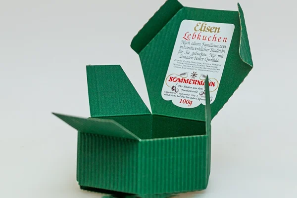 Seitenansicht des offenen grünen Geschenkkarton mit Etikett zum Inhalt